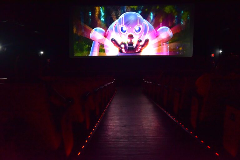 Crianças e adultos assistem a filme em sessão adaptada para pessoas com TEA no Cine Henfil, em Maricá.