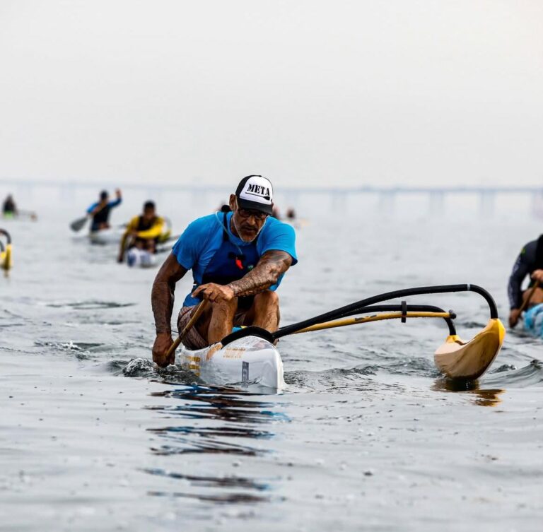 Atletas remam canoa havaiana em competição na Praia de Icaraí, Niterói. Circuito Super Paddle 2026.