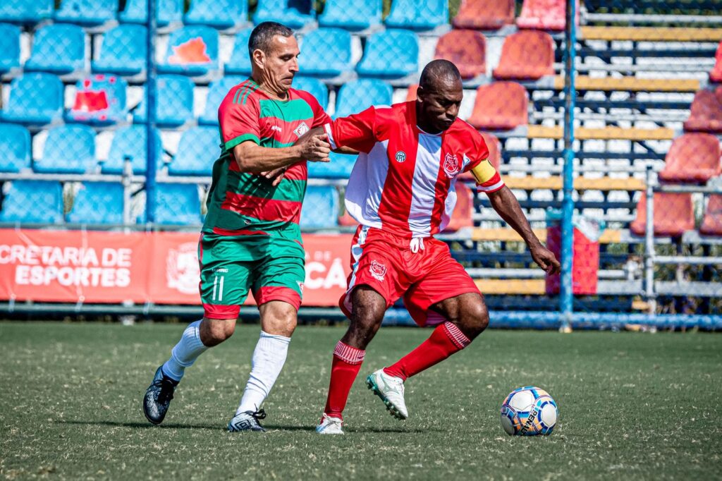 Jogadores de futebol amador em campo durante partida da Taça Cidade de Maricá.