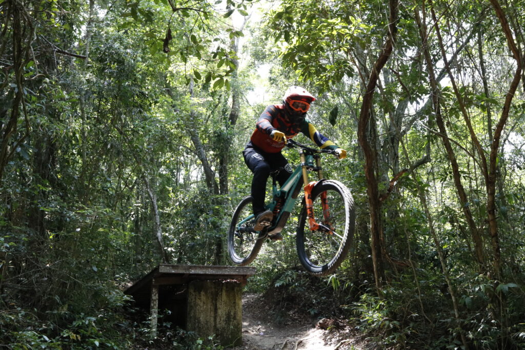 Atleta de downhill descendo trilha em alta velocidade no Parque da Cidade, Niterói, durante etapa internacional de ciclismo.