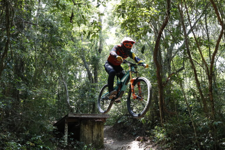 Atleta de downhill descendo trilha em alta velocidade no Parque da Cidade, Niterói, durante etapa internacional de ciclismo.