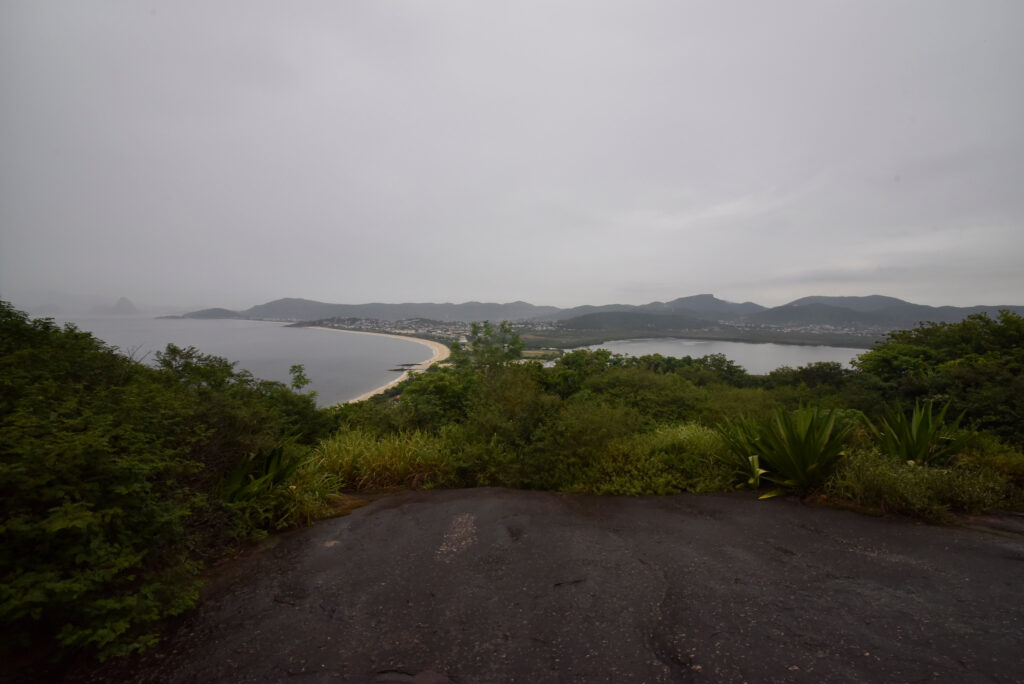 Pessoas com deficiência em trilha inclusiva em Niterói, usando cadeira adaptada, acompanhadas por equipe.
