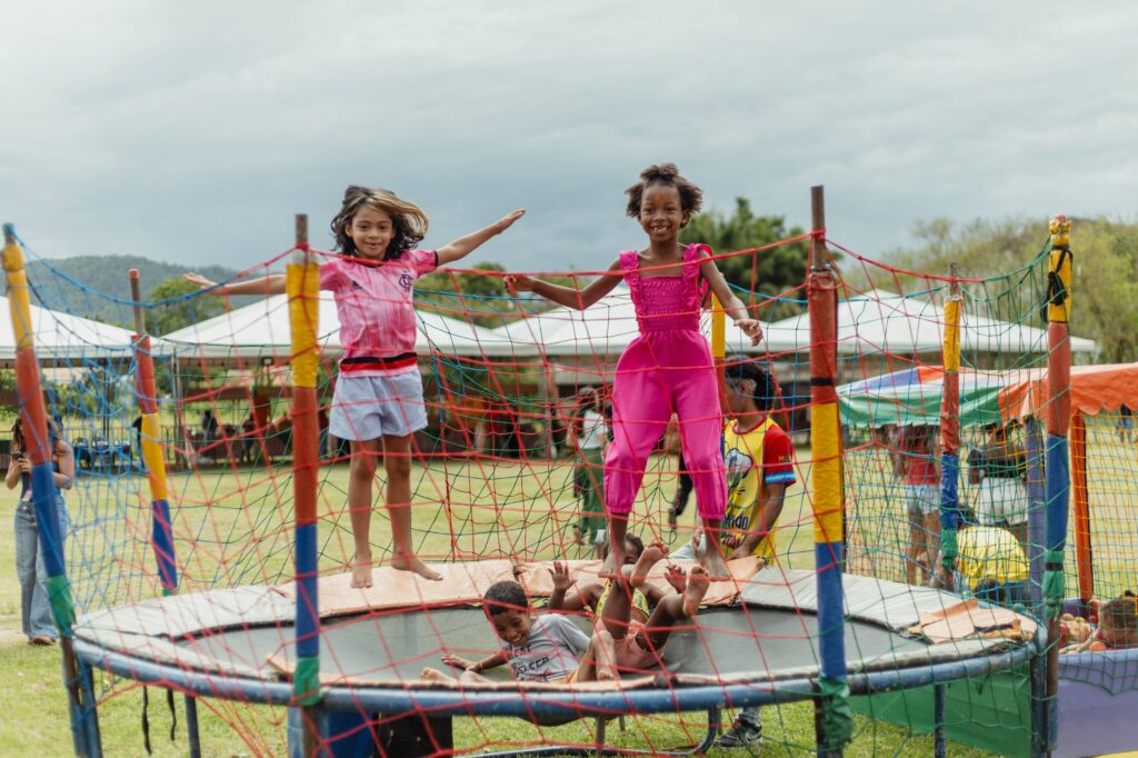 Crianças brincam em evento de Páscoa com coelho e brinquedos infláveis em Inoã, Maricá.