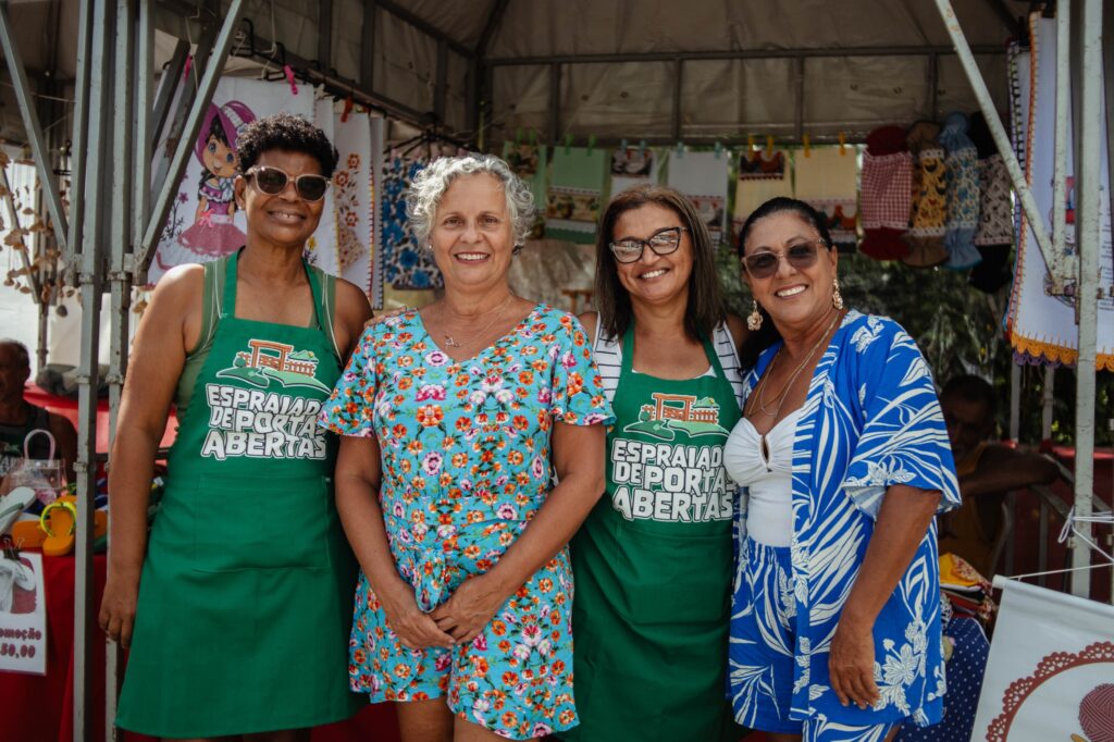 Pessoas em evento de Páscoa no Espraiado, Maricá, com coelhinho da Páscoa e atividades ao ar livre.