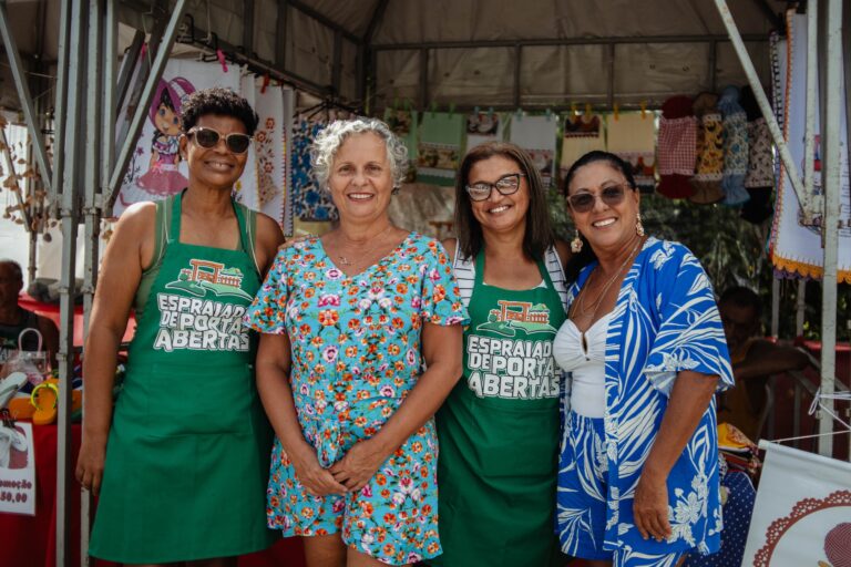 Pessoas em evento de Páscoa no Espraiado, Maricá, com coelhinho da Páscoa e atividades ao ar livre.