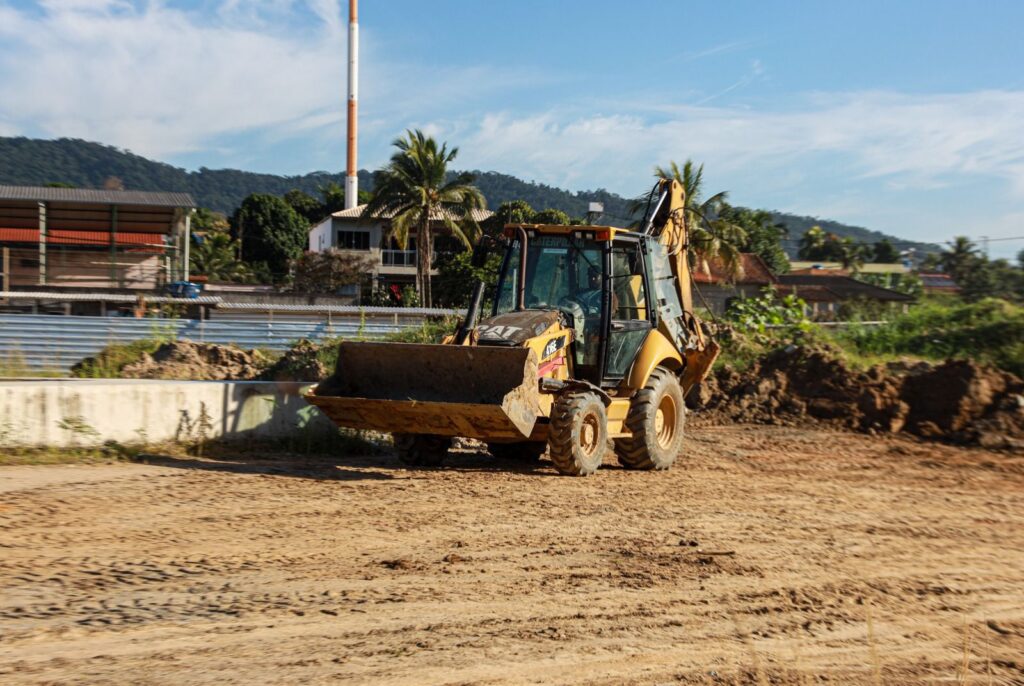 Obras do novo Campus de Educação Pública Transformadora (CEPT) Eduardo Galeano em Inoã, Maricá, com maquinário e trabalhadores.