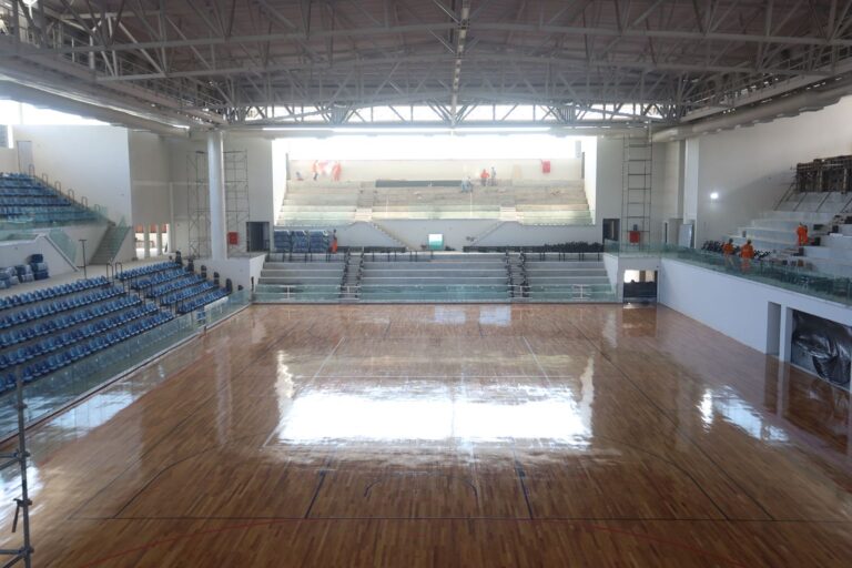 Prefeito Rodrigo Neves vistoria obras da Arena Niterói em fase final, com quadra e assentos visíveis.