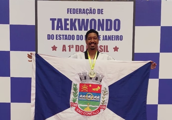 Atleta Sherman Sant'Ana, de São Gonçalo, comemora medalha de ouro em competição de Taekwondo. Tema: esporte e incentivo municipal.