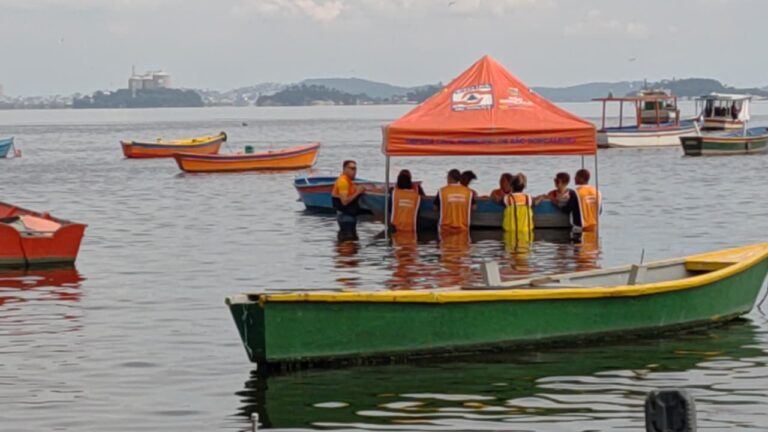 Voluntários da Defesa Civil de São Gonçalo praticam evacuação de barco em simulação de alagamento na Praia das Pedrinhas.