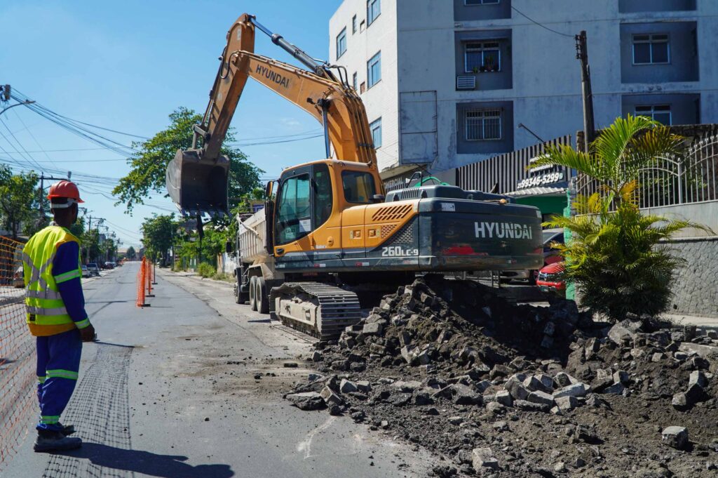 Vista aérea das obras de pavimentação e construção de ciclovia do projeto MUVI em São Gonçalo, com tráfego de veículos.