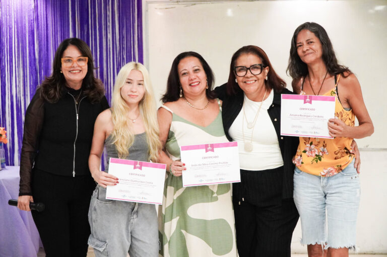 Mulheres formandas do Lidera Mulher em São Gonçalo recebem certificados em cerimônia com autoridades.