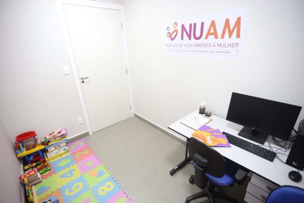 Mulher amamenta bebê em sala, com profissionais de saúde ao lado, simbolizando acolhimento em Niterói.
