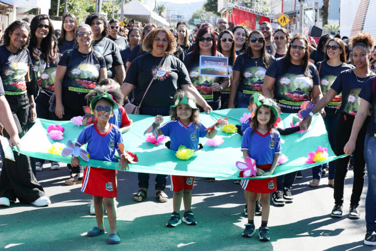 Estudantes de Maricá desfilam em celebração aos 212 anos da cidade, com bandeiras e uniformes escolares.
