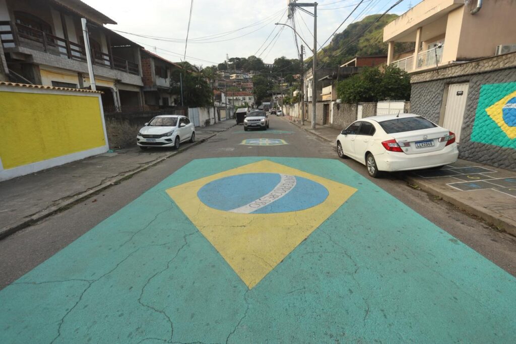 Moradores decoram rua em Niterói com bandeirinhas e cores do Brasil para a Copa do Mundo.