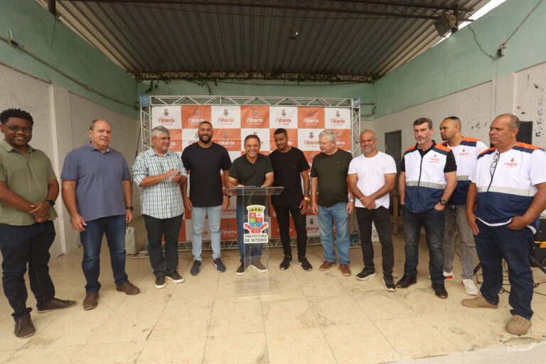 Parque de energia solar no Morro do Boa Vista, Niterói, com painéis fotovoltaicos e vegetação em área de comunidade.
