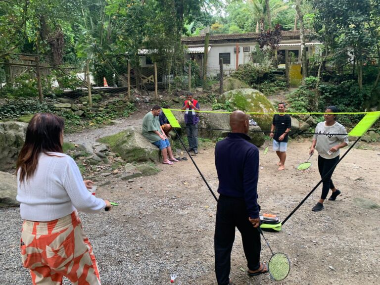 Acolhidos da Casa Abrigo Mumbuca em Maricá participam de atividade de badminton ao ar livre.