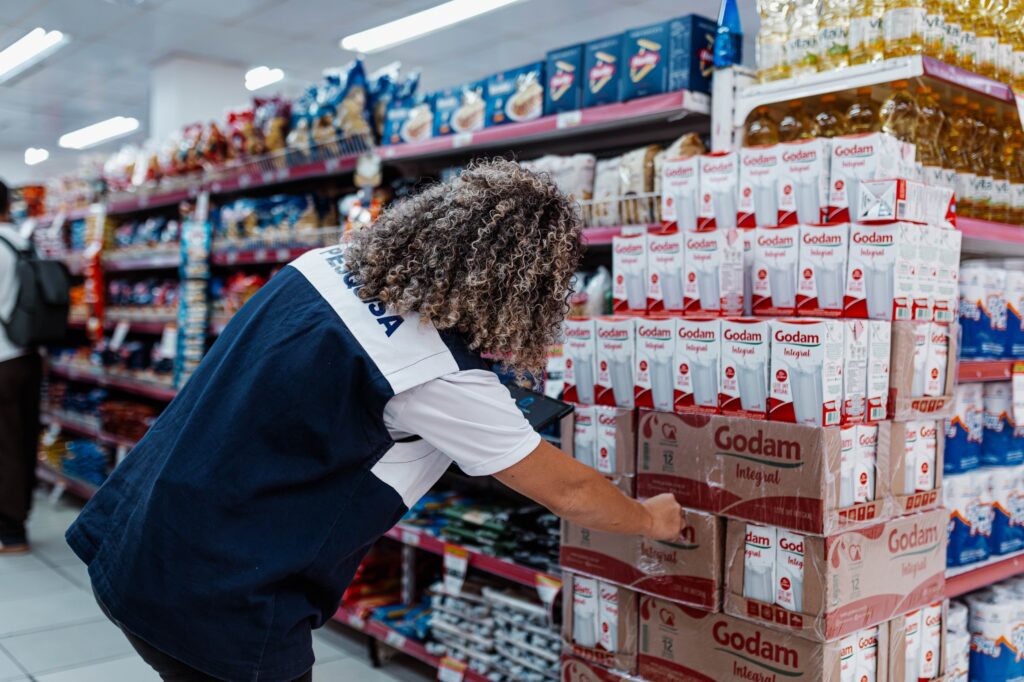 Pesquisadores do IDR de Maricá conversam com comerciante em frente a um estabelecimento para coleta de dados.