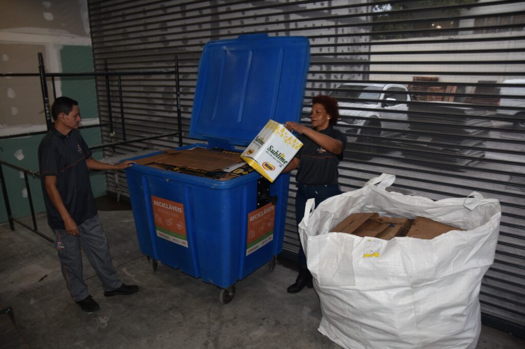 Funcionários do Mercado Municipal de Niterói recebem capacitação sobre coleta seletiva com novos contêineres para reciclagem.
