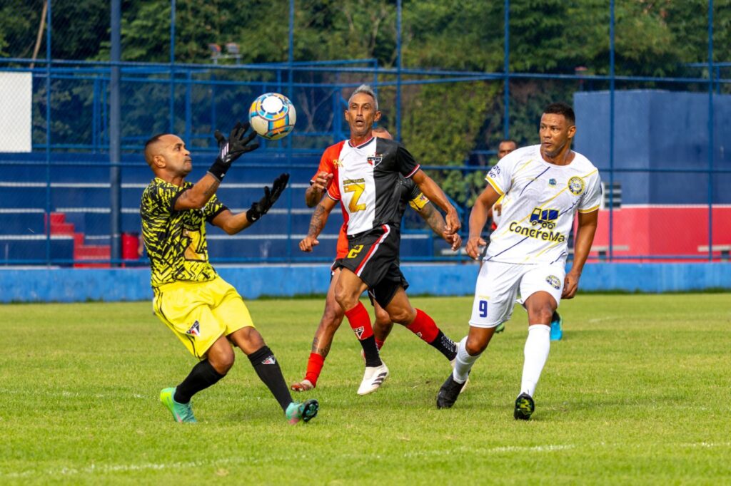 Jogadores de futebol amador comemoram durante partida da Taça Cidade de Maricá.