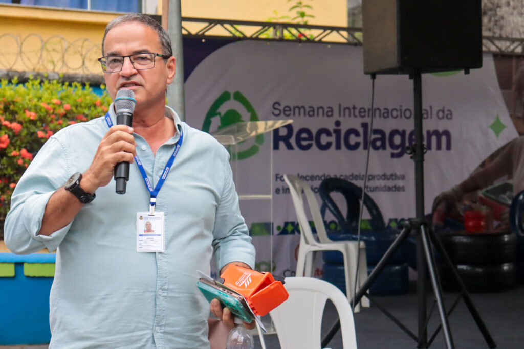 Pessoas participam de evento de reciclagem em praça de São Gonçalo, com estandes e atividades educativas.
