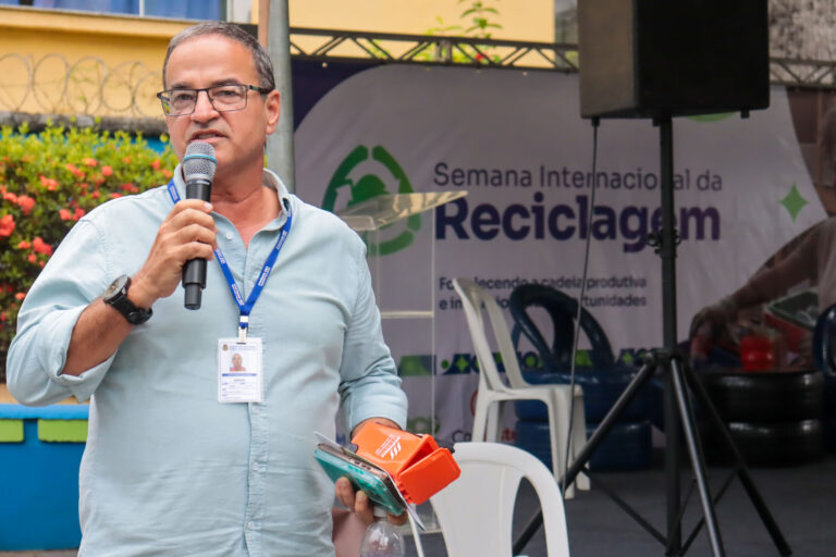 Pessoas participam de evento de reciclagem em praça de São Gonçalo, com estandes e atividades educativas.