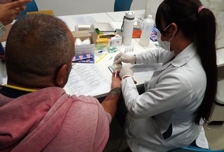 Profissional de saúde realiza atendimento a funcionário durante ação da Prefeitura de São Gonçalo.