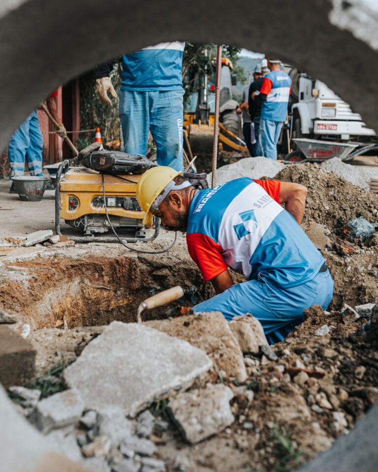 Obras de implantação do sistema de esgotamento sanitário em Santa Paula, Maricá, com máquinas e trabalhadores.