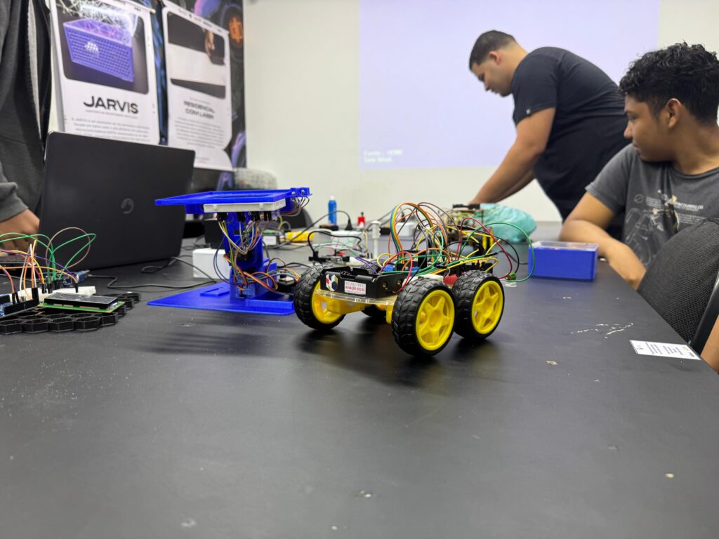Jovens e adultos em Maricá participam de aula prática em laboratório de robótica e tecnologia.