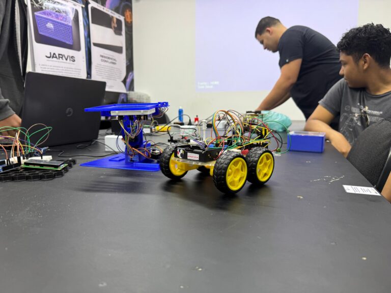 Jovens e adultos em Maricá participam de aula prática em laboratório de robótica e tecnologia.