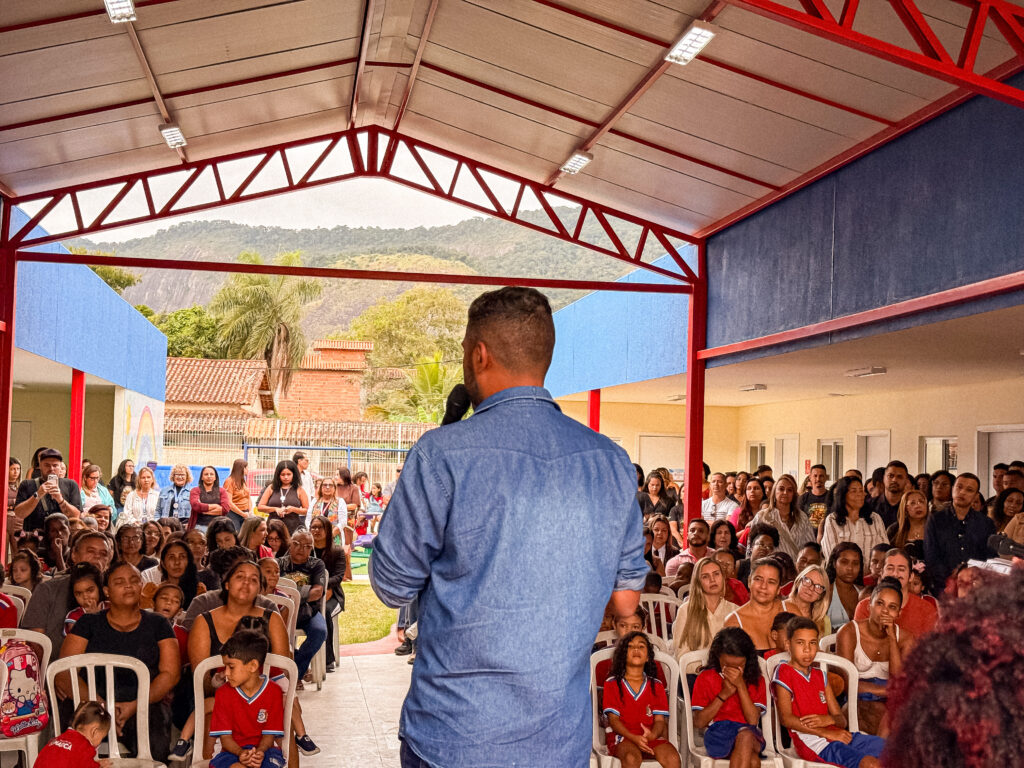 Fachada da Escola Municipal Romilda Nunes em Maricá, com alunos e autoridades na inauguração da unidade modernizada.