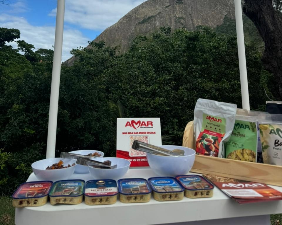 Feira de produtos da agricultura familiar em Maricá, com barracas coloridas e pessoas interagindo.