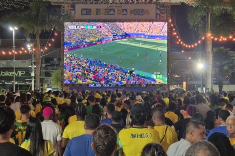 Telão montado em praça pública de Maricá com torcedores acompanhando jogo da Seleção Brasileira durante a Copa.