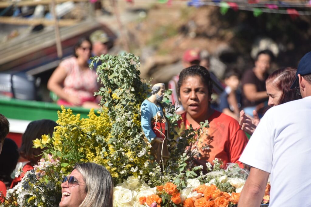Barcos decorados com bandeiras coloridas e imagens de São Pedro em procissão aquática na Festa de São Pedro em Maricá.