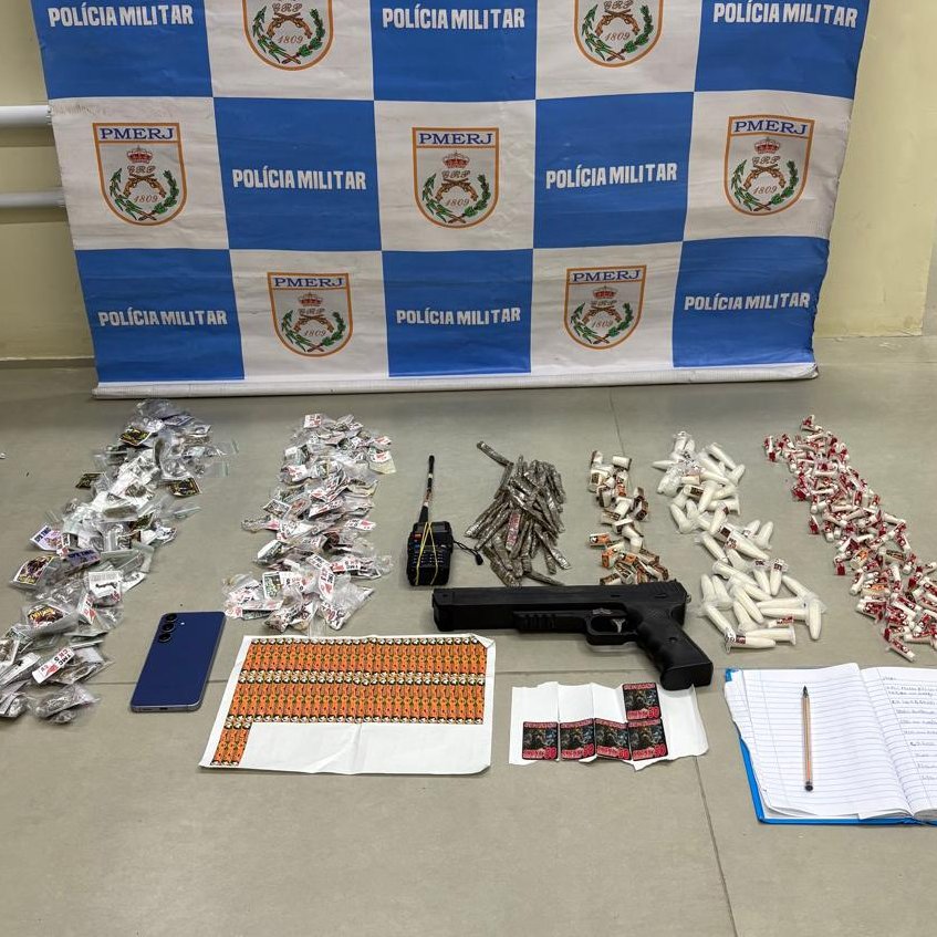 Policiais militares em São Gonçalo, com drogas e uma réplica de pistola apreendidas, após prisão de foragido.