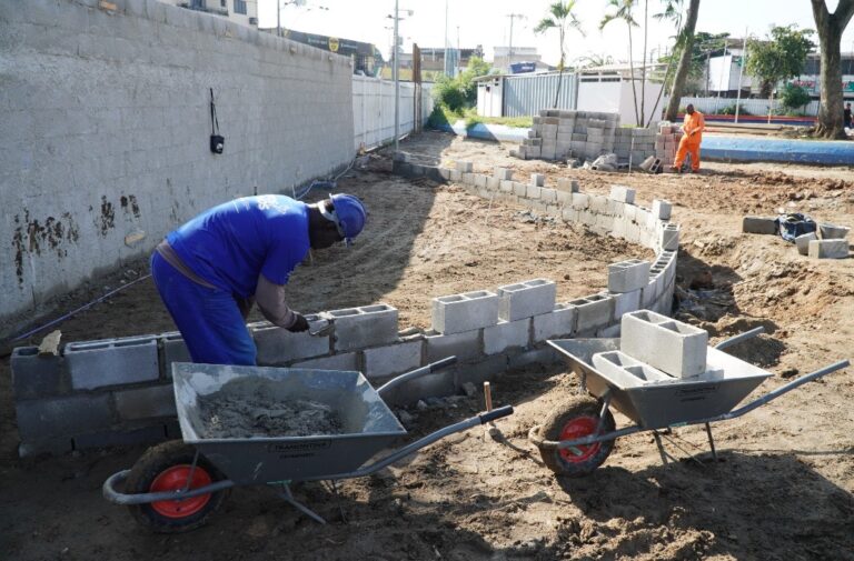 Trabalhadores instalam novo piso drenante na Praça da Trindade em São Gonçalo, parte da reforma e modernização do espaço.