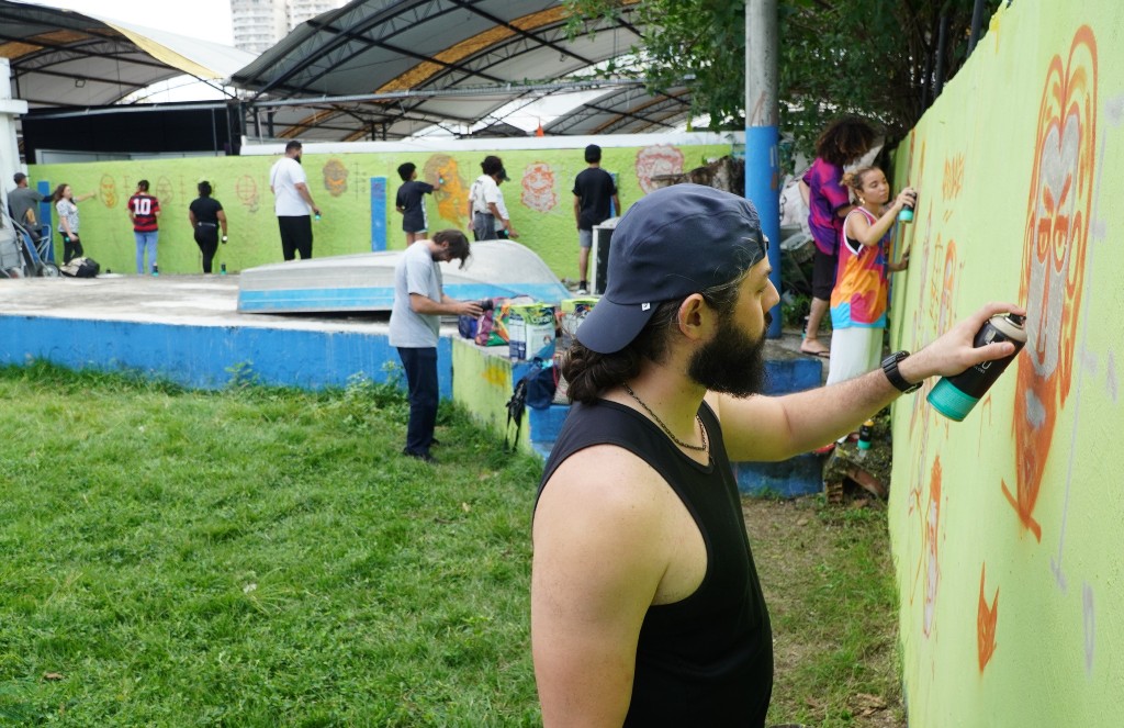 Jovens participam de aula de graffiti no Centro Cultural Joaquim Lavoura em São Gonçalo, com orientadores.