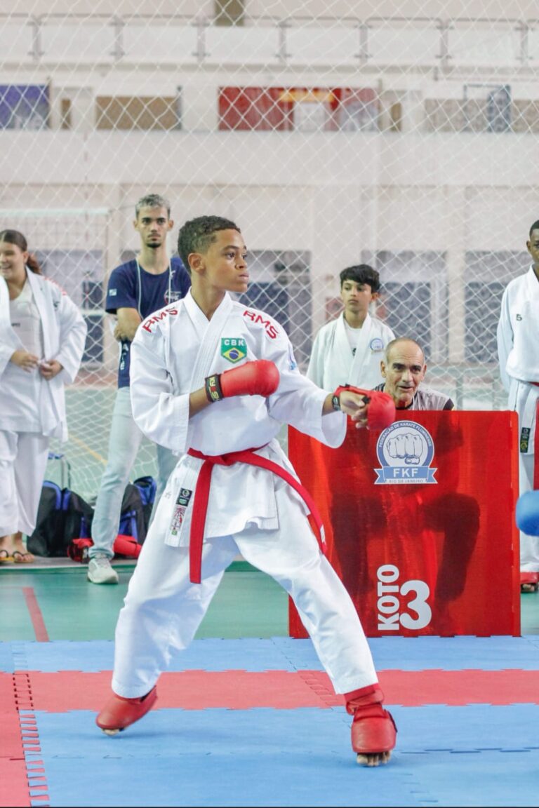 Alex Pereira, atleta de karatê de São Gonçalo, em posição de luta, com o uniforme da seleção brasileira, em destaque.