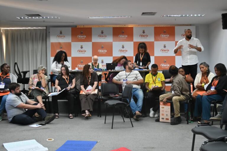 Cerca de 100 pessoas participam de formação sobre políticas públicas em Niterói, com palestrantes e público atento.