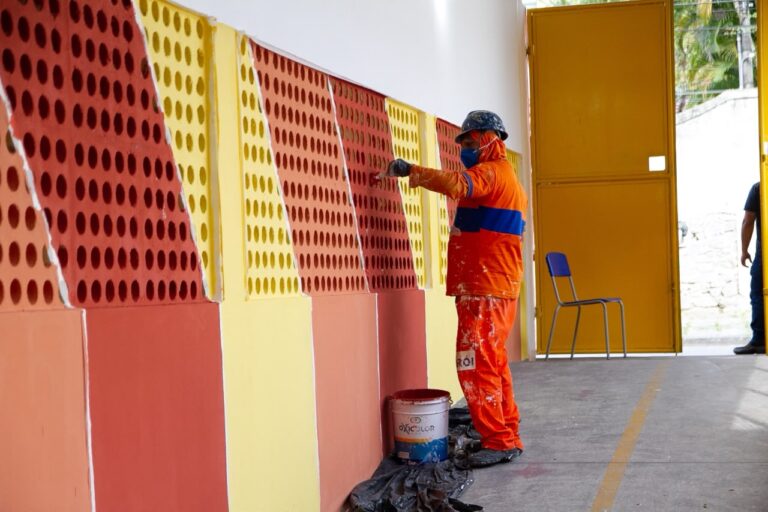 Trabalhador realiza manutenção em telhado de escola municipal em Niterói durante o recesso escolar.