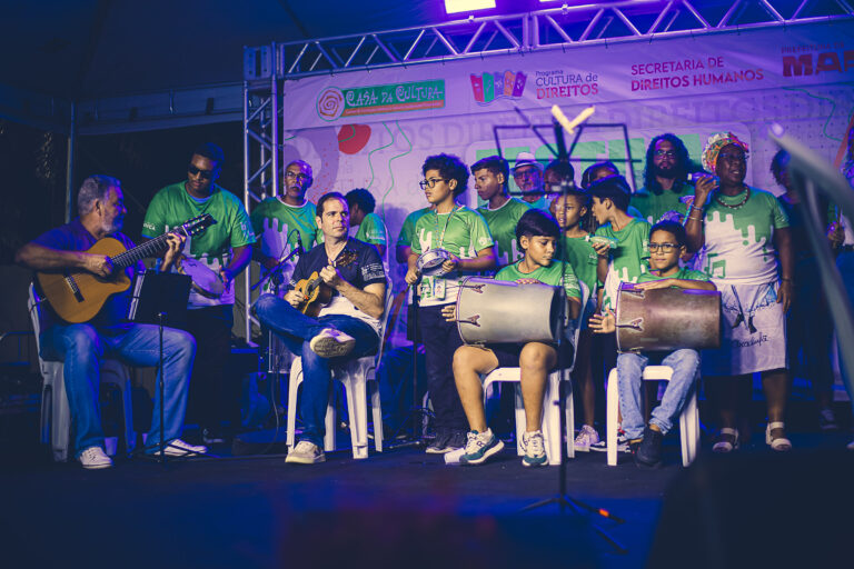 Alunos participam de oficina cultural gratuita em Maricá, aprendendo música e arte.