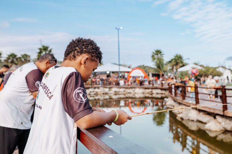 Crianças e adultos participam de evento de pesca esportiva na orla de Bambuí, Maricá.