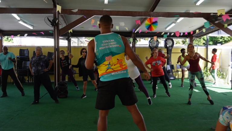 Idosos sorrindo e dançando em aula de dança criativa em Maricá