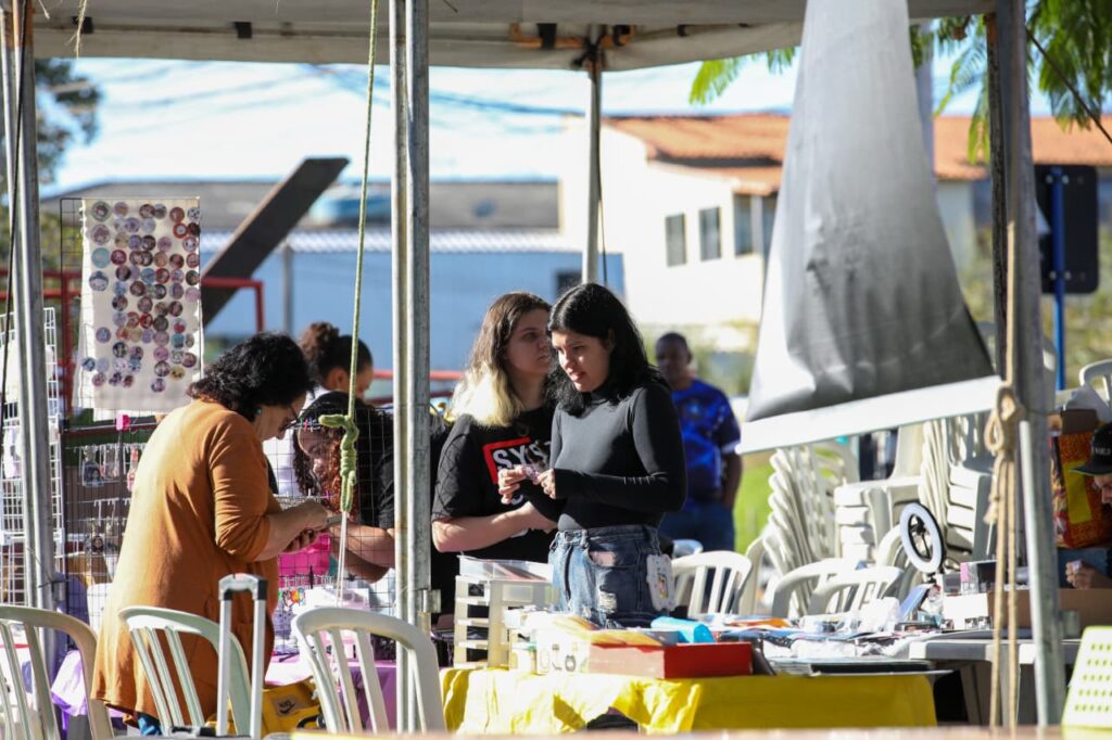 Pessoas em evento cultural com shows e feira geek na Praça dos Gaviões, Itaipuaçu, Maricá.