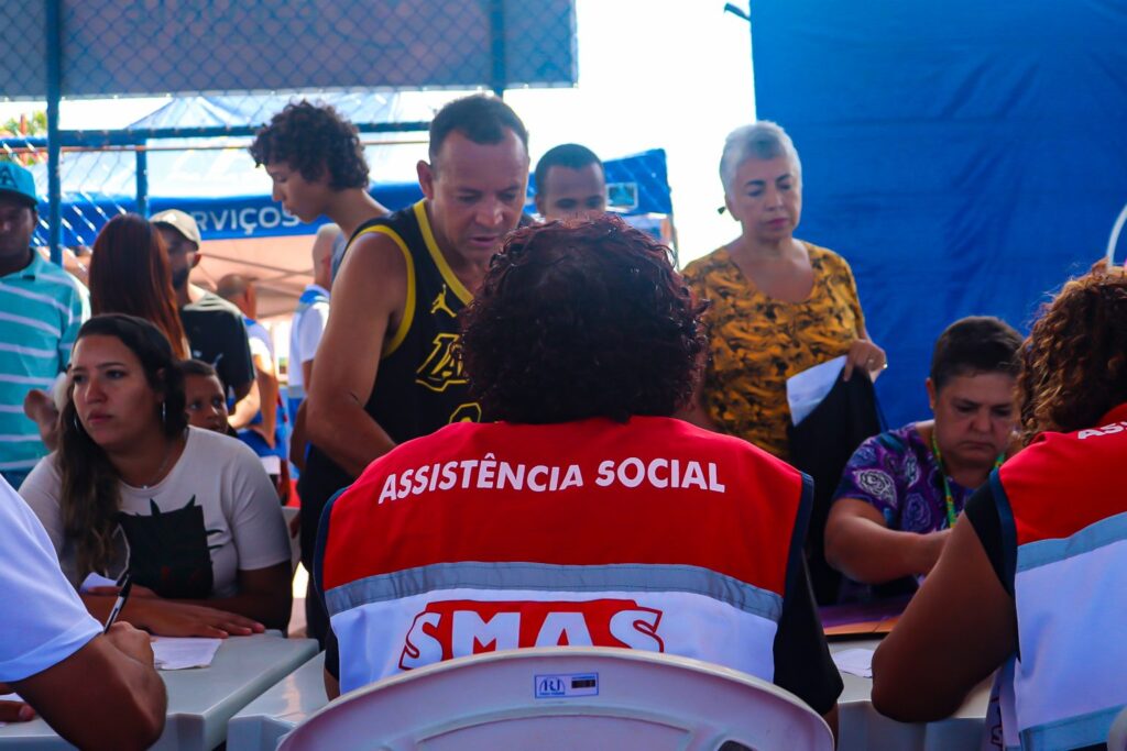 Moradores recebendo atendimento em ação de cidadania e assistência social em Maricá.