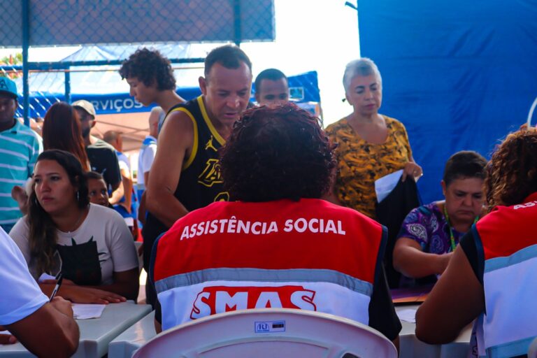 Moradores recebendo atendimento em ação de cidadania e assistência social em Maricá.