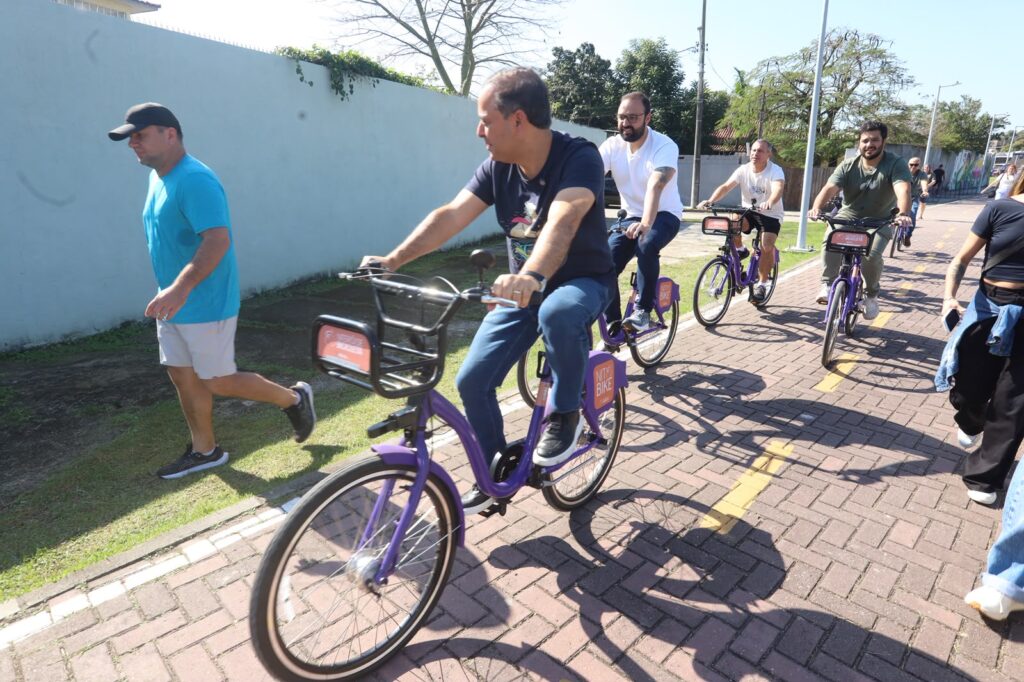 Famílias em Niterói usando bicicletas NitBike compartilhadas na Região Oceânica, Piratininga.