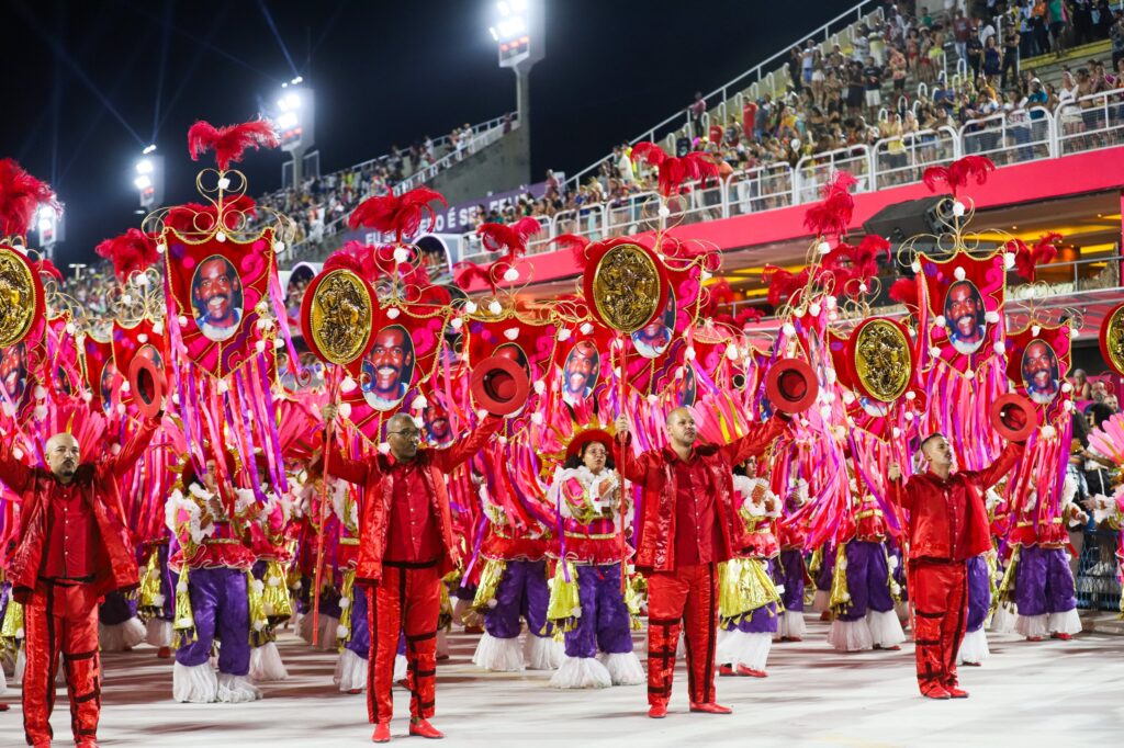 Componentes da União de Maricá desfilam com fantasias coloridas na Sapucaí, representando o Carnaval.