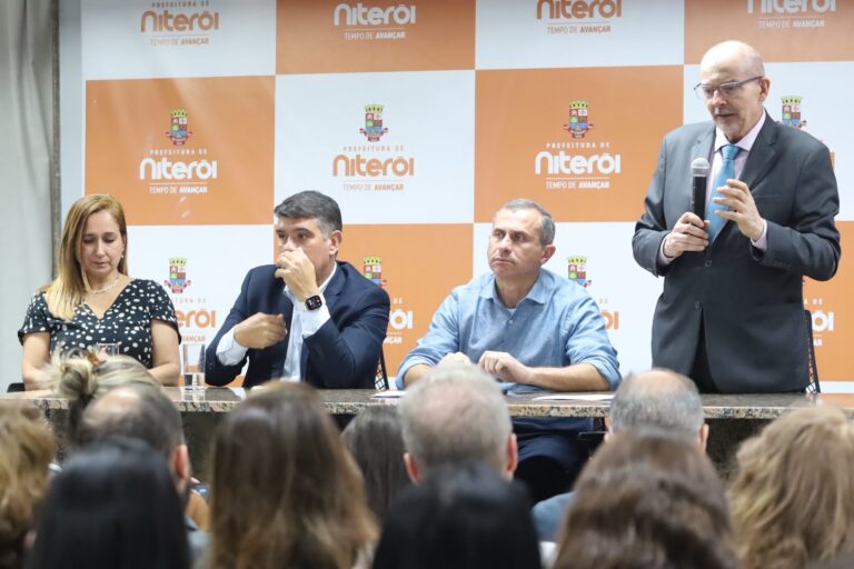 Cerimônia de entrega de cheques simbólicos do programa Niterói Empreendedora com autoridades e beneficiários.