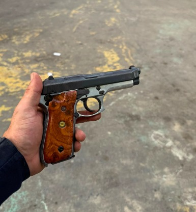 Policiais militares em operação com material apreendido, como arma, drogas e rádio transmissor.