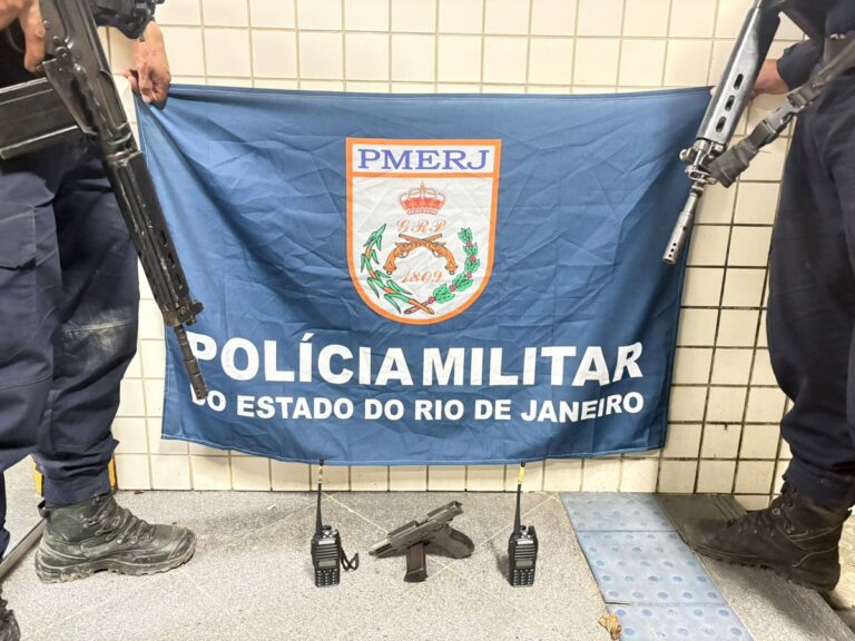Policiais militares exibem pistola, munições e rádios transmissores apreendidos em Niterói.